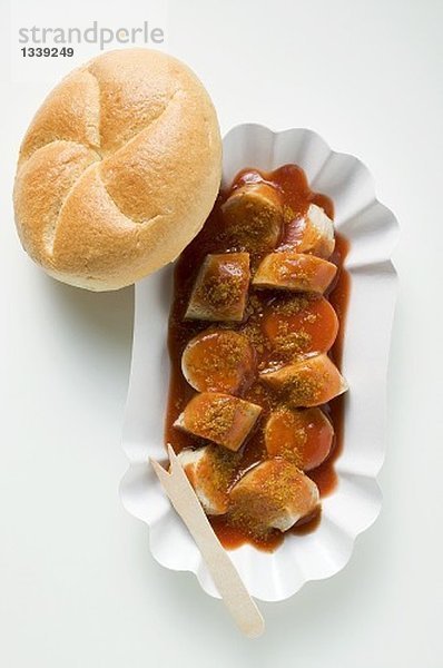 Bratwurst mit Ketchup und Curry auf Pappteller  Brötchen