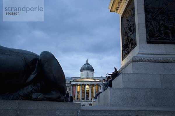 Touristen sitzen auf Schritten des Denkmals am Stadtplatz  Trafalgar Square  Westminster  London  England