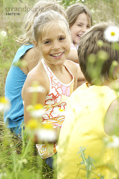 Seitenansicht vier Kinder sitzen in Feld