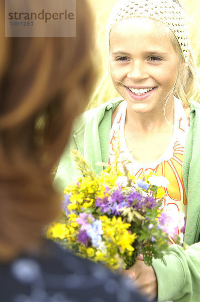 Nahaufnahme Mädchen hält Blumenstrauß und Blick auf ihre Freundin