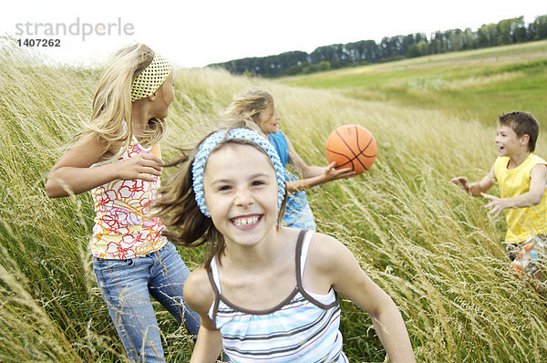 Vier Kinder spielen im Feld