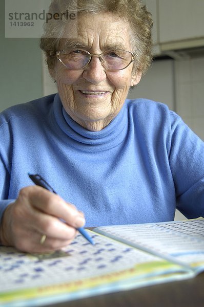 Senior Frau macht Kreuzworträtsel
