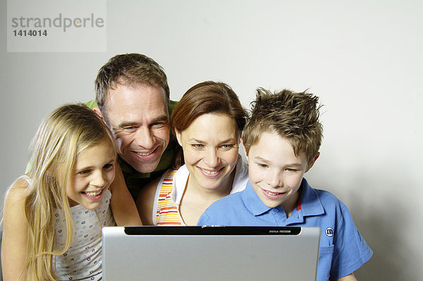 Familie schauen  Laptop und lächelnd