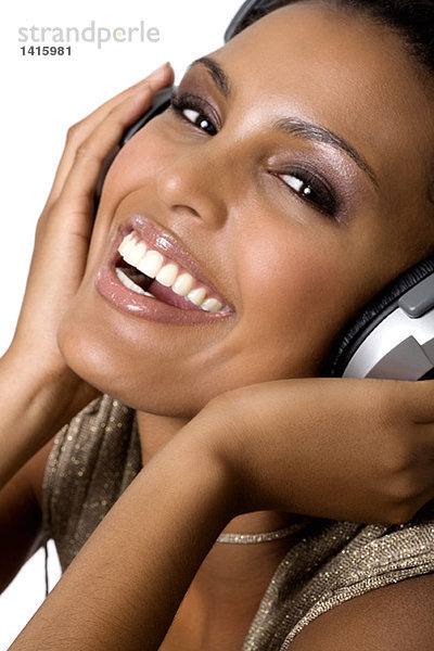 Porträt einer jungen lächelnden Frau  Musik hören mit Kopfhörer