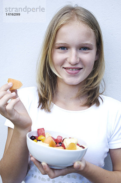 Porträt eines jungen Mädchens beim Obstsalatessen
