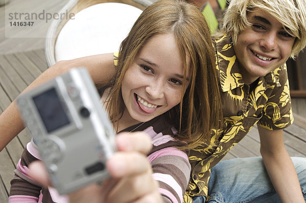 Teenager Mädchen und Junge  die sich selbst fotografieren.