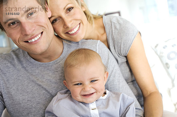 Portrait Eltern und Baby lächelnd  drinnen