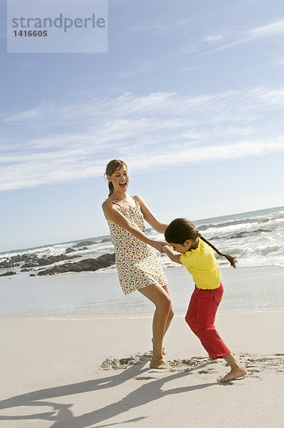 Mutter und Tochter beim Spielen am Strand  im Freien