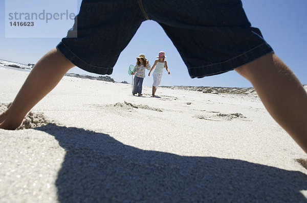 Drei Kinder beim Spielen am Strand  im Freien