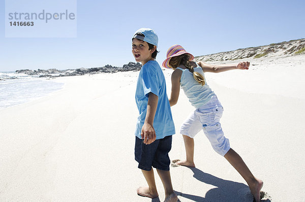 Bruder und Schwester beim Spaziergang am Strand  im Freien