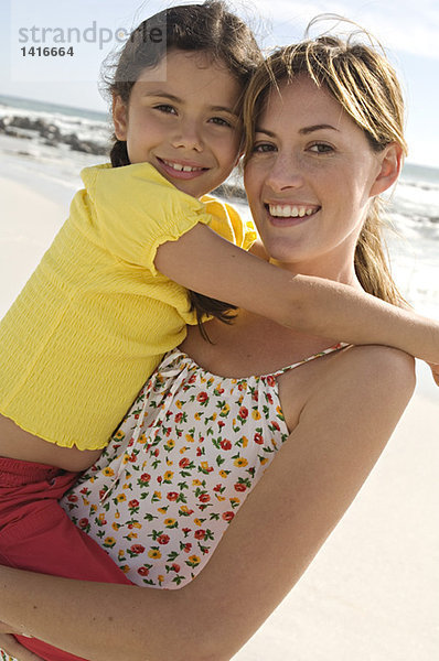 Porträt einer Mutter mit ihrer Tochter  lächelnd  posierend für die Kamera  im Freien
