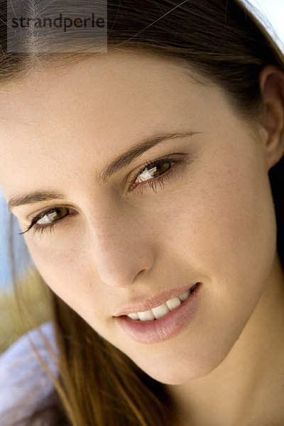 Porträt einer jungen Frau lächelnd  mit Blick auf die Kamera  drinnen