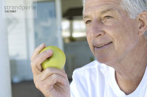 Porträt eines älteren Mannes mit einem Apfel
