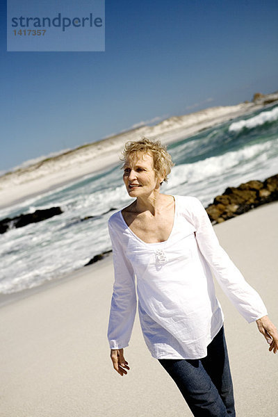 Seniorin beim Spaziergang am Strand