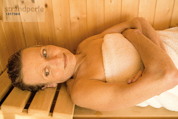 Seniorin in der Sauna liegend