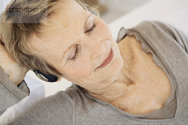 Seniorin beim Musikhören mit Kopfhörern