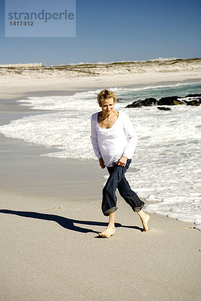 Seniorin beim Spaziergang am Strand