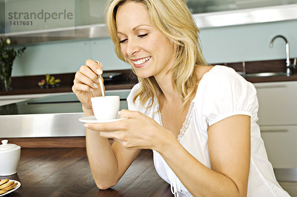 Junge lächelnde Frau mit Kaffeetasse