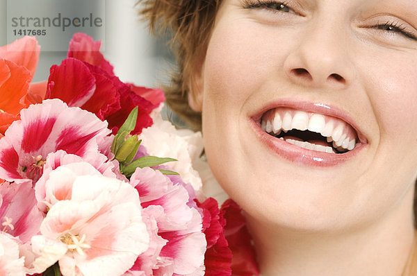 Porträt einer lächelnden Frau mit Blumenstrauß