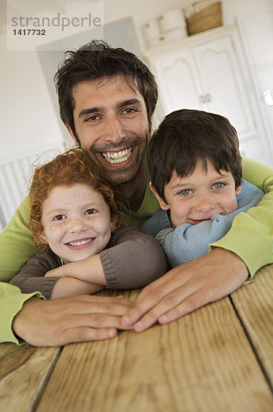 Vater und 2 Kinder lächeln für die Kamera