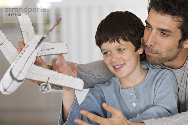 Vater und Sohn spielen mit dem Modellflugzeug