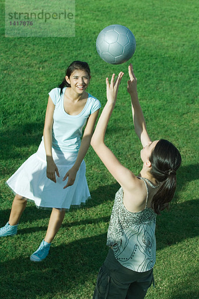 Zwei junge Freundinnen beim Spielen mit dem Fußball