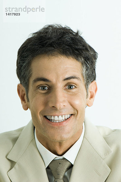Mann schaut in die Kamera mit zahnfarbenem Lächeln  Kopf und Schultern  Portrait