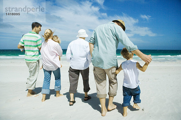 Drei Generationen Familienwandern am Strand  Rückansicht