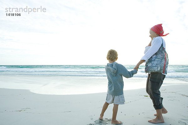 Seniorin am Strand stehend mit Enkelin