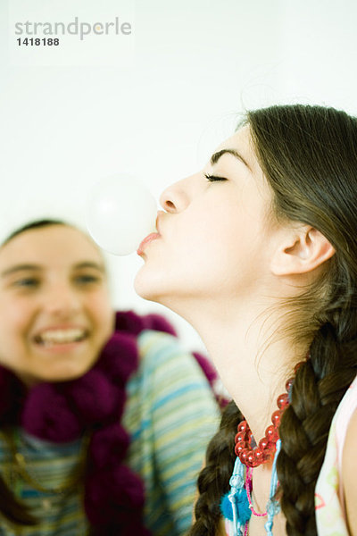 Zwei junge Freundinnen  eine Blasenblase mit Kaugummi