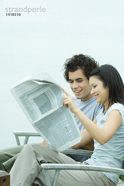 Junges Paar liest Zeitung