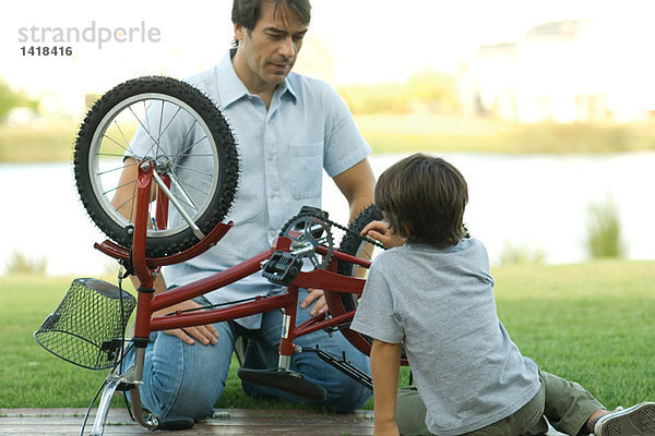 Vater und Sohn reparieren Fahrrad zusammen