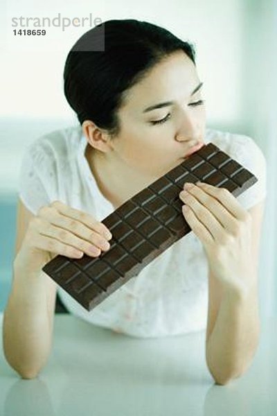 Frau küsst große Tafel Schokolade