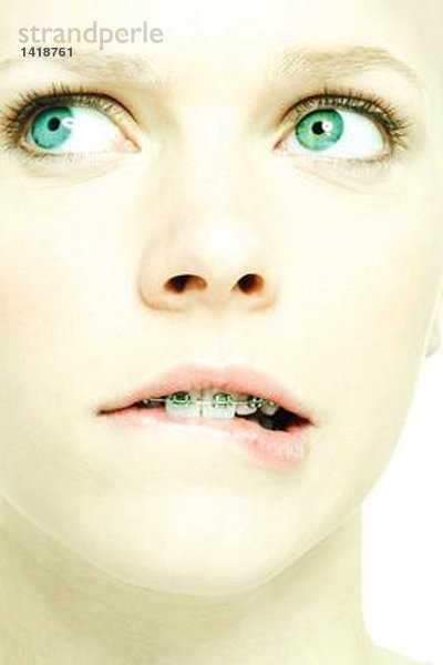 Teenagermädchen mit Klammern beißende Lippe  extreme Nahaufnahme  Mund