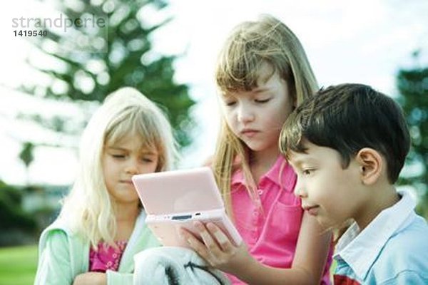 Kinder auf dem Spielplatz  Videospiel spielen