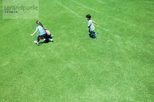 Kinder beim Ballspielen auf Rasen