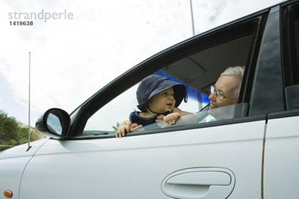 Seniorin und Baby im Auto