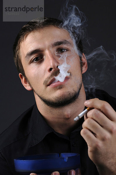 Mann beim Anzünden einer Zigarette  Porträt
