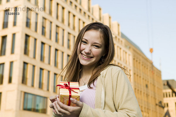 Junge Frau  die ein Geschenk hält