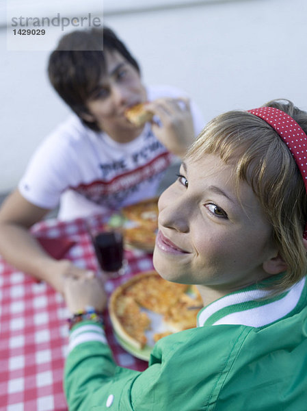 Junges Paar beim Pizzaessen im Freien