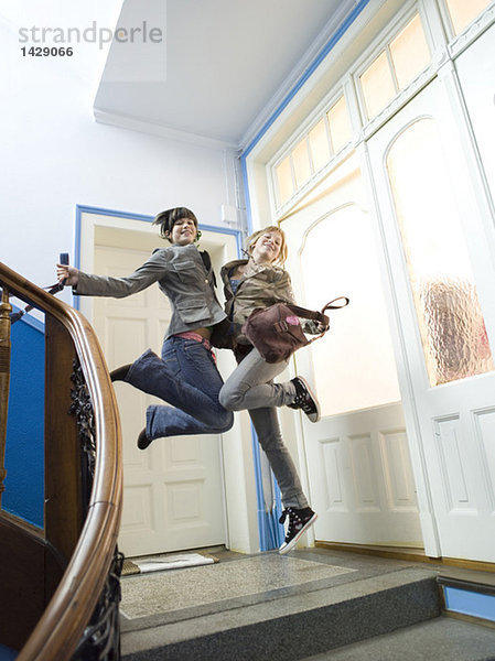Zwei Mädchen springen auf der Treppe