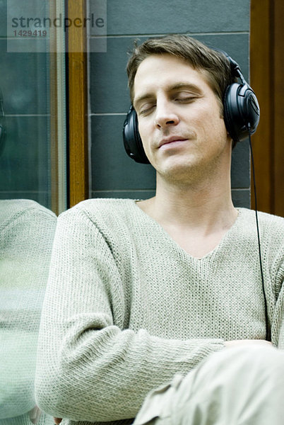 Mann mit geschlossenen Kopfhöreraugen