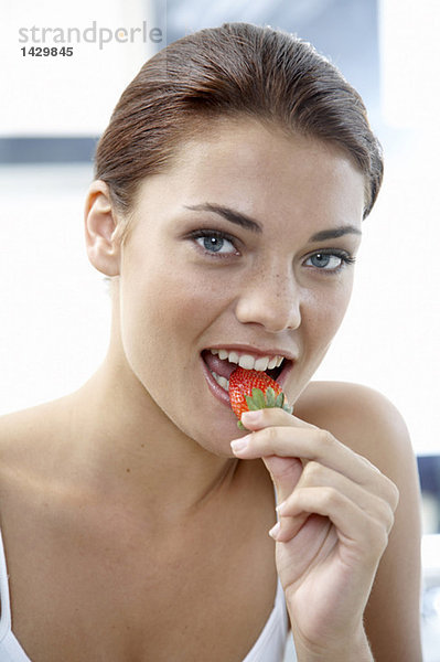 Junge Frau isst Erdbeere