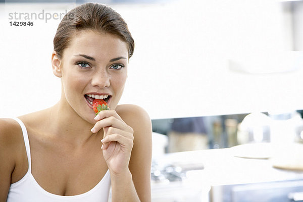 Junge Frau isst Erdbeere