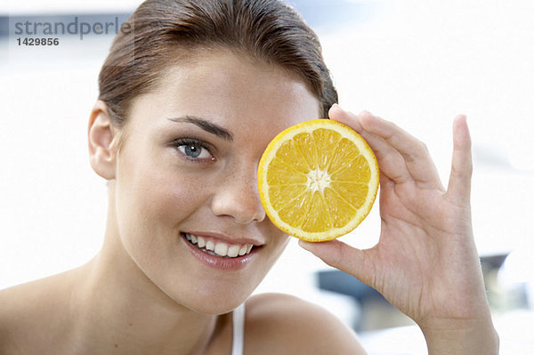 Junge Frau mit Orangenscheiben