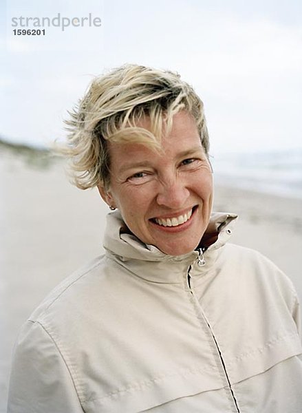 Porträt von einem lächelnd middle-aged Woman am Meer.