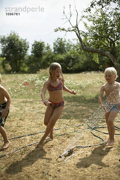 Kinder spielen in einem Garten.