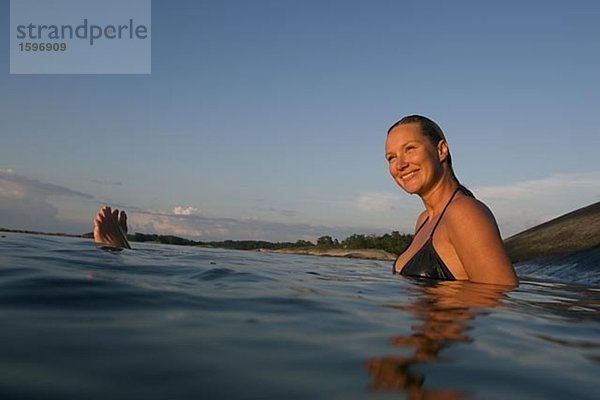 Eine Frau in den Schären schwimmen.