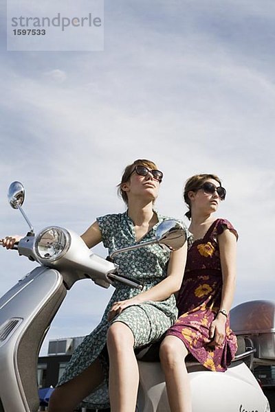 Zwei junge skandinavische Frauen auf einem Motorroller Schweden.