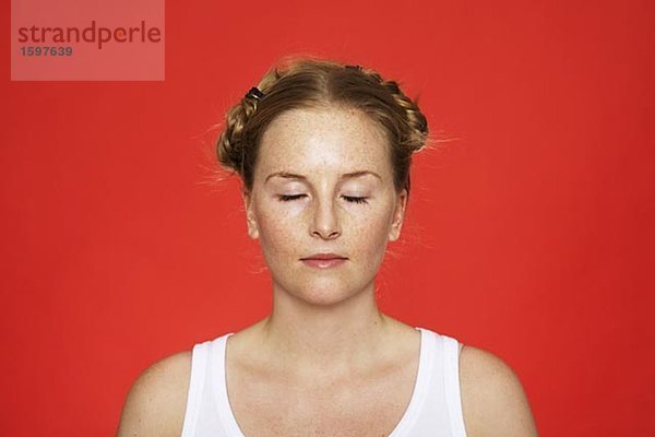 Eine Frau mit Zöpfen schließen ihre Augen.